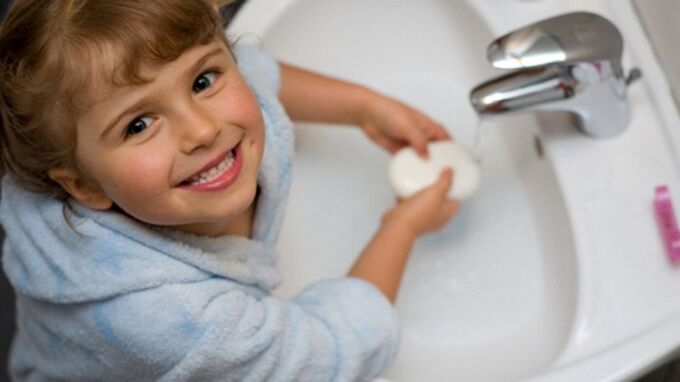child wash hands with soap to prevent worms